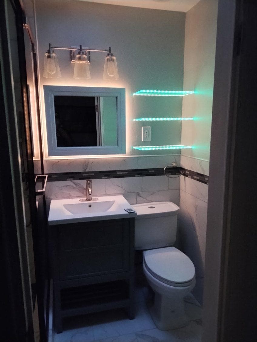 picture of a newly remodeled bathroom with custom neon green lighting shelves